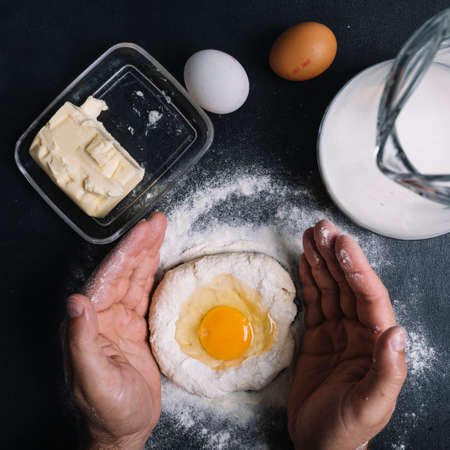 Beat flour and kitchen utensils, a baking dish, a rolling pin with eggs on the table. Baking, cooking concept. Chef making bread and gingerbread cookies. The cook kneads and rolls the dough.の写真素材