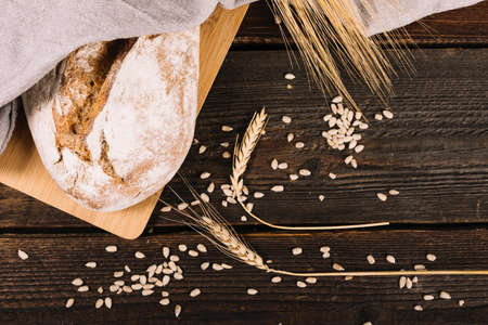Different baking buns, croissants, gingerbread cookies. Delicious freshly baked bread on wooden background with place for text. Fresh loaves of bread And sliced ââbreads containing sesame seeds.の写真素材