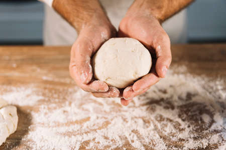 Beat flour and kitchen utensils, a baking dish, a rolling pin with eggs on the table. Baking, cooking concept. Chef making bread and gingerbread cookies. The cook kneads and rolls the dough.の写真素材