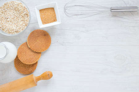 Flour and kitchen utensils whisk, baking dish, rolling pin with eggs on the table. Baking, cooking...