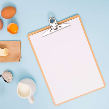 Flour and kitchen utensils whisk, baking dish, rolling pin with eggs on the table. Baking, cooking...