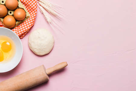 Flour and kitchen utensils whisk, baking dish, rolling pin with eggs on the table. Baking, cooking concept, top view with place for text.の写真素材