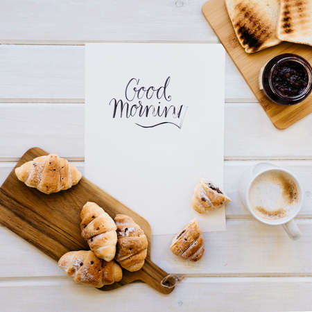 Croissant and cup of coffee on a wooden table with place for text.の写真素材