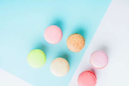 Colorful macarons pattern background. Bakery sweets concept background. Cake macaron or macaroon on turquoise background from above, colorful almond cookies, pastel colors, vintage card.の写真素材