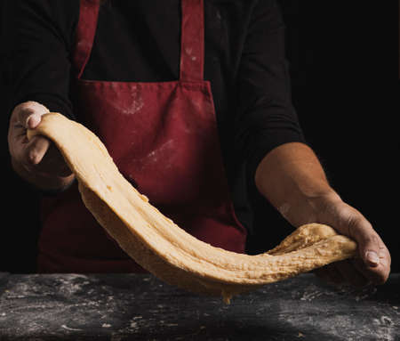 Beat flour and kitchen utensils, a baking dish, a rolling pin with eggs on the table. Baking, cooking concept. Chef making bread and gingerbread cookies. The cook kneads and rolls the dough.の写真素材