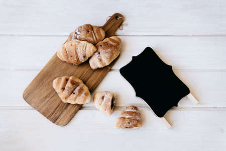 Croissant and cup of coffee on a wooden table with place for text.の写真素材