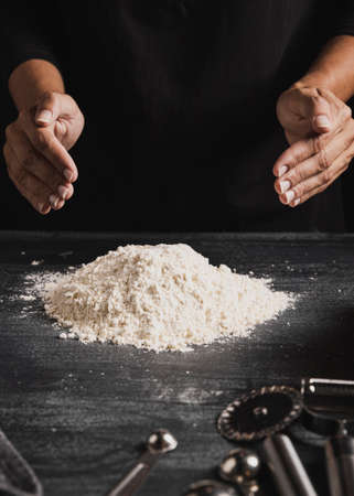 Beat flour and kitchen utensils, a baking dish, a rolling pin with eggs on the table. Baking, cooking concept. Chef making bread and gingerbread cookies. The cook kneads and rolls the dough.の写真素材