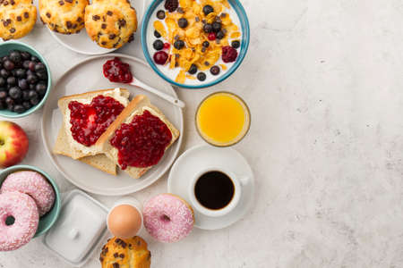 Healthy breakfast - muesli with blueberry and honey, yogurt, growing, juice and coffee. Selective focus. Top view. Flat layの写真素材