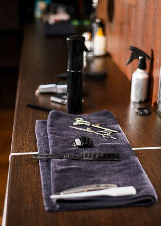 Vintage tools of barber shop on wooden background. Electric hair trimmer, vintage straight razors, a comb, wax and brush on the wooden background, close-up. Place to insert your text. Hipster groomingの写真素材