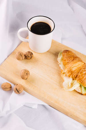 Delicious Breakfast with Croissant sandwiches with Fried Egg, Salad Leaves and avocado. Coffee, healthy breakfast.の写真素材