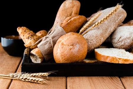 Different baking buns, croissants, gingerbread cookies. Delicious freshly baked bread on wooden...