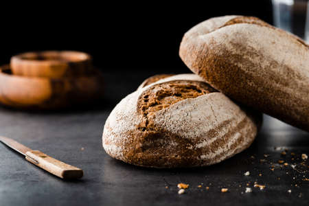 Different baking buns, croissants, gingerbread cookies. Delicious freshly baked bread on wooden background with place for text. Fresh loaves of bread And sliced ââbreads containing sesame seeds.の写真素材