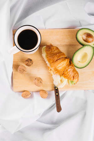 Delicious Breakfast with Croissant sandwiches with Fried Egg, Salad Leaves and avocado. Coffee, healthy breakfast.の写真素材