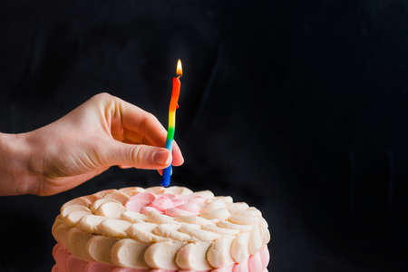 Woman's hands cut the cake with cream on wood background. Woman holding piece of cake on shovel over...