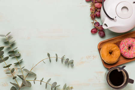 Sweet donuts with coffee or tea. Teapot. A gentle composition on a wooden table for the presentation...