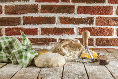 Flour and kitchen utensils whisk, baking dish, rolling pin with eggs on the table. Baking, cooking...