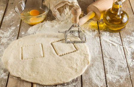 Flour and kitchen utensils whisk, baking dish, rolling pin with eggs on the table. Baking, cooking...