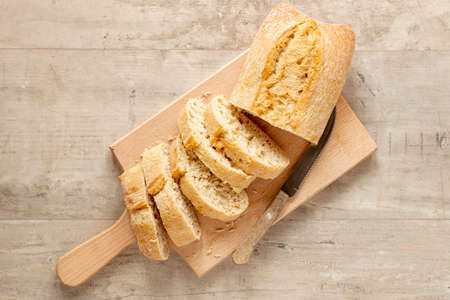 various bakery products with loaf bread and a baker tearing bread