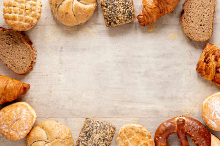 Different baking buns, croissants, gingerbread cookies. Delicious freshly baked bread on wooden...