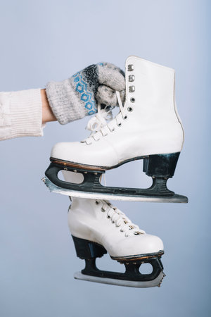 Woman holding white skates hand. High quality photo