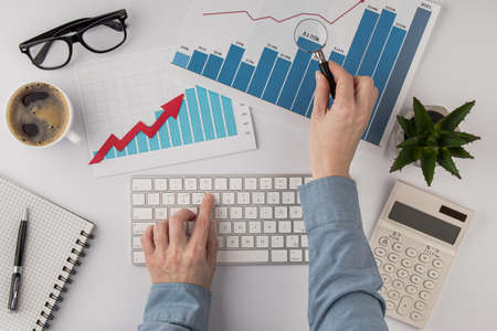 top view office desk with growth chart hands with keyboard. Resolution and high quality beautiful...