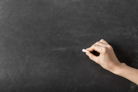 person writing with chalk empty blackboard. Resolution and high quality beautiful photoの写真素材