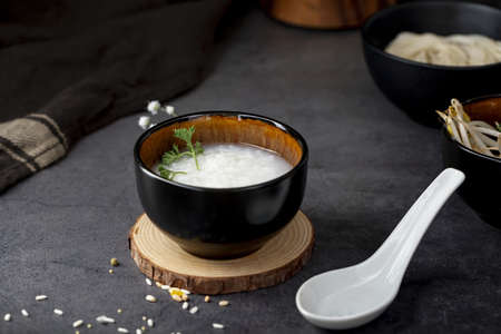 rice soup black bowl wooden support white spoon. Resolution and high quality beautiful photo