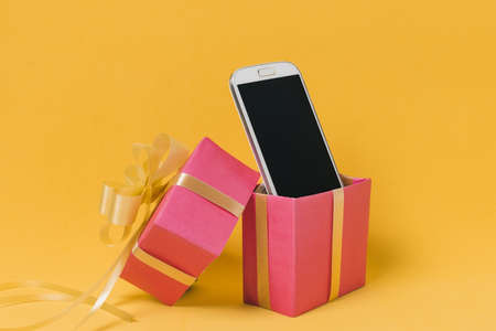 mobile phone with blank screen pink gift box. Resolution and high quality beautiful photoの写真素材