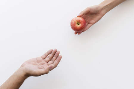 hand giving apple needy person. Resolution and high quality beautiful photoの写真素材