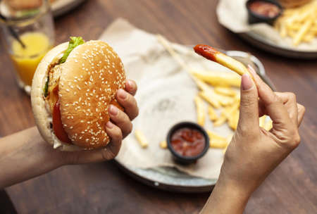 high angle person eating burger french fries. Resolution and high quality beautiful photoの写真素材