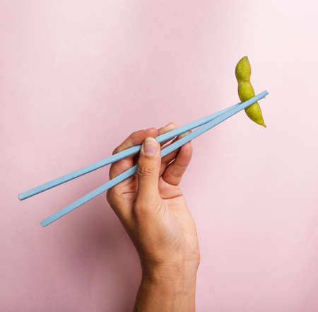 hand holding chopsticks with edamame bean. Resolution and high quality beautiful photoの写真素材