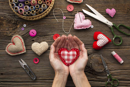 hands holding a red heart shape on wooden background. Resolution and high quality beautiful photoの写真素材