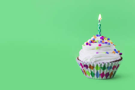 close up delicious cupcake with burning candle green background. Resolution and high quality beautiful photoの写真素材
