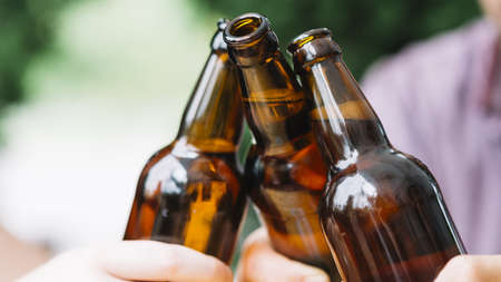close up friends clinking brown beer bottles. Resolution and high quality beautiful photoの写真素材