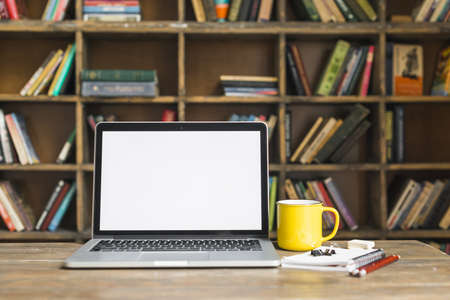 coffee mug laptop with stationeries wooden desk library. Resolution and high quality beautiful photoの写真素材