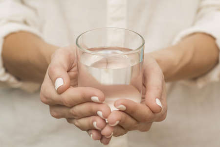 woman holding glass filled with water. High quality beautiful photo concept