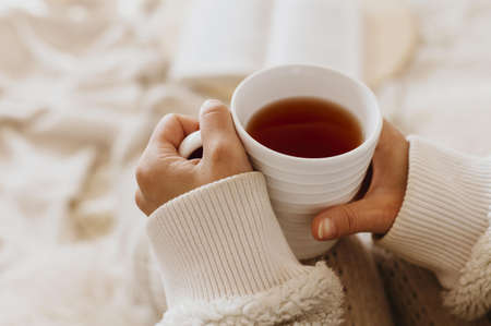 young woman holding cup tea while enjoying winter holidays. High quality beautiful photo conceptの写真素材