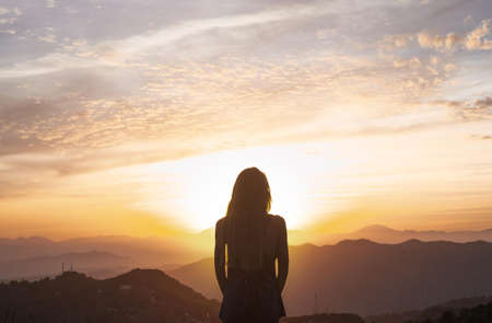 back view woman doing yoga while watching sunset. High quality beautiful photo conceptの写真素材