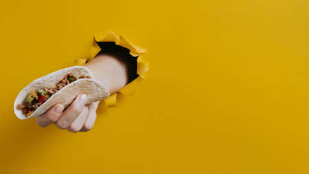 close up hand holding taco with copy space. High quality beautiful photo conceptの写真素材