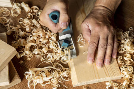 carpenter working wood surrounded by sawdust. High quality beautiful photo concept