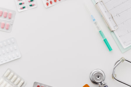 many blister pills pack with syringe stethoscope ecg report clipboard white backdrop. High quality beautiful photo conceptの写真素材