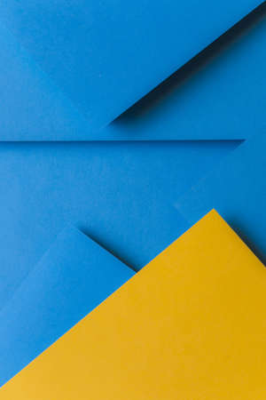 creative arrangement yellow blue colored paper creating abstract background. High quality beautiful photo conceptの写真素材