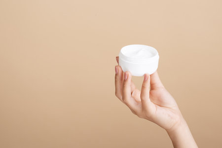 close up hand holding cream jar. High quality beautiful photo conceptの写真素材