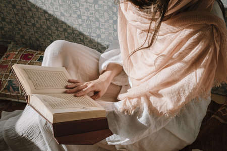 sitting woman reading quran.の写真素材