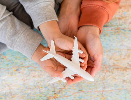 mother child home holding airplane figurine top mapの写真素材