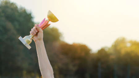 female hand raising trophyの写真素材