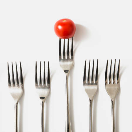 red cherry tomato fork against white backgroundの写真素材