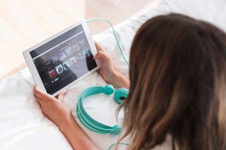 young woman holding tablet with spotify app. High quality photo