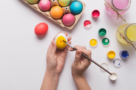 crop hands painting chick egg