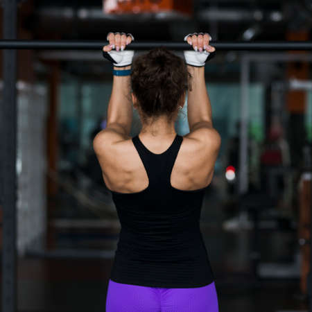 back view woman performing pull ups